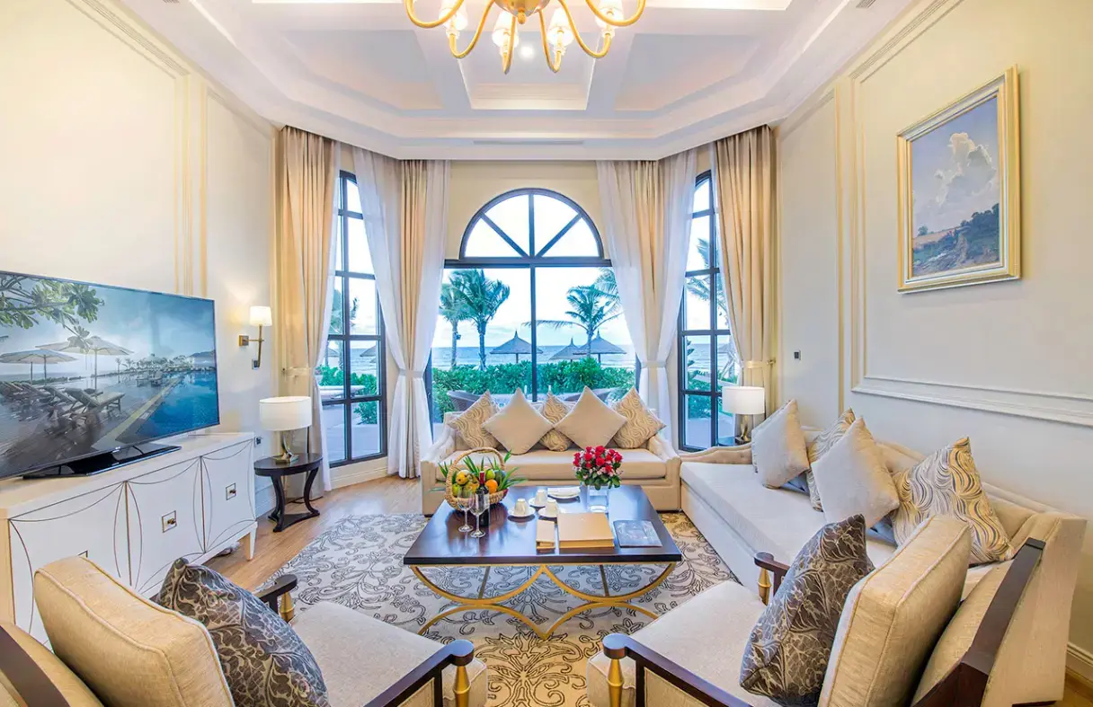 Phòng khách villa Đà Nẵng rộng rãi, thoáng đãng với nội thất sang trọng, view hồ bơi và vườn.