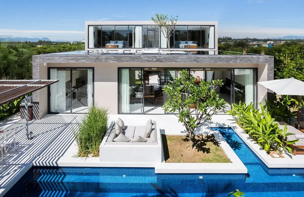 Exterior of a spacious Da Nang villa with a large private swimming pool and lush outdoor lounge area.